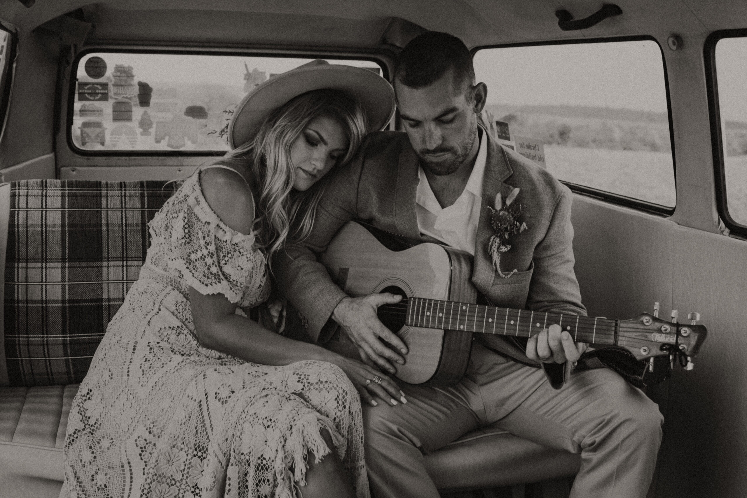 man and woman sitting together in a van while the man plays guitar. elopement photographer in Texas for adventure and destination elopements