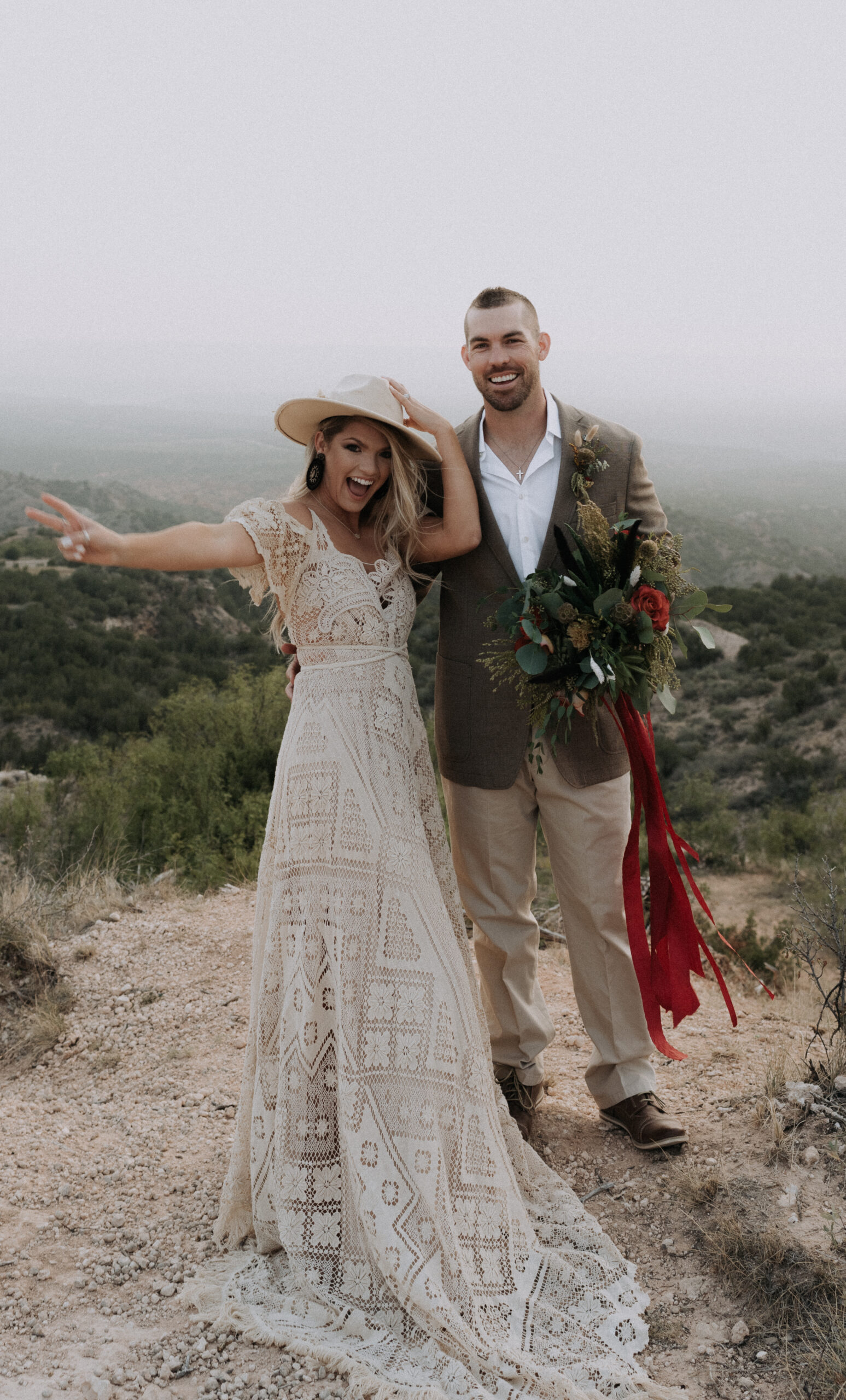 man and woman posing on top of a canyon and smiling. elopement photoshoot and elopement photographer based in Texas