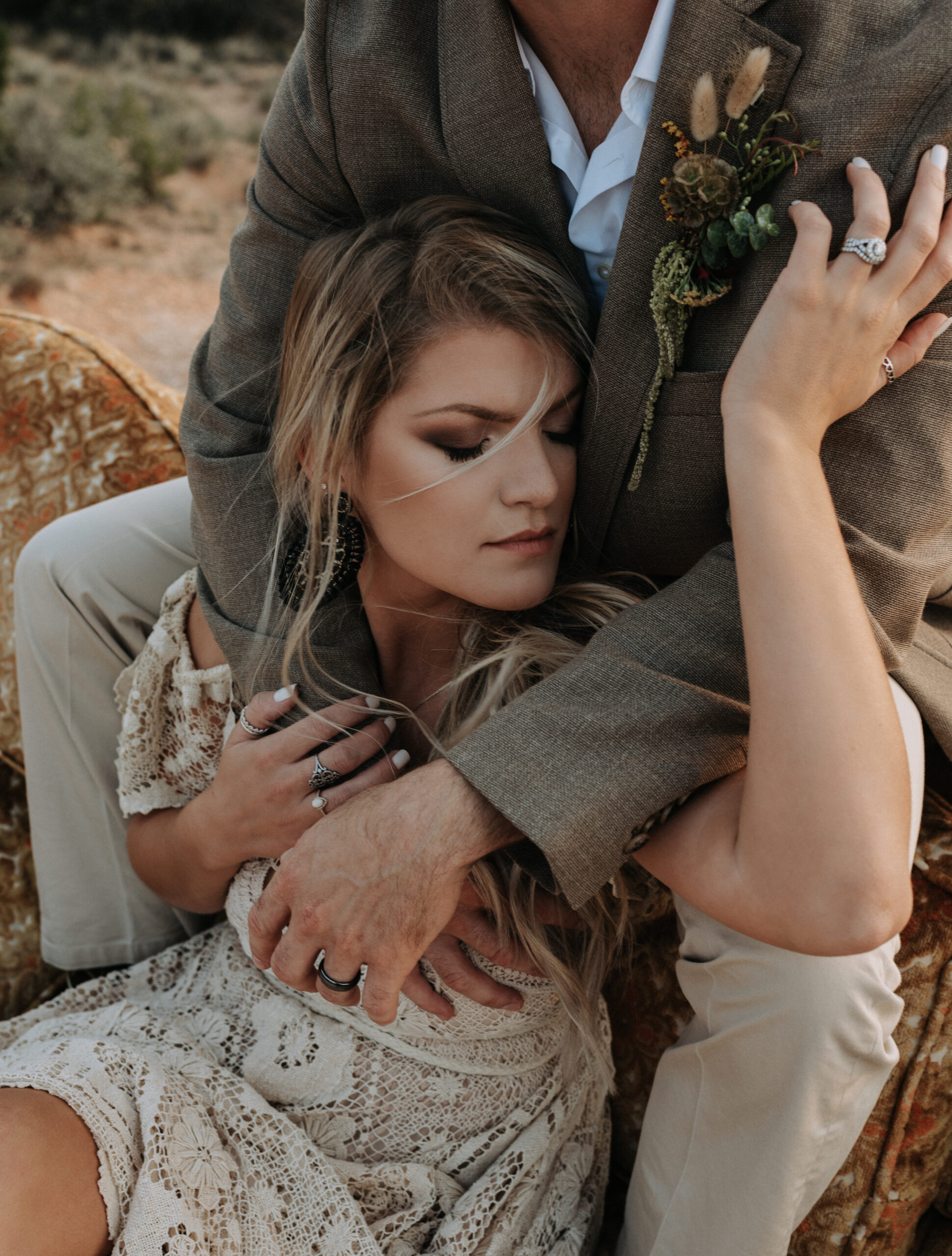 man and woman sitting on couch while posing for elopement photos with a background of a canyon. elopement photographer in texas for destination elopement photography