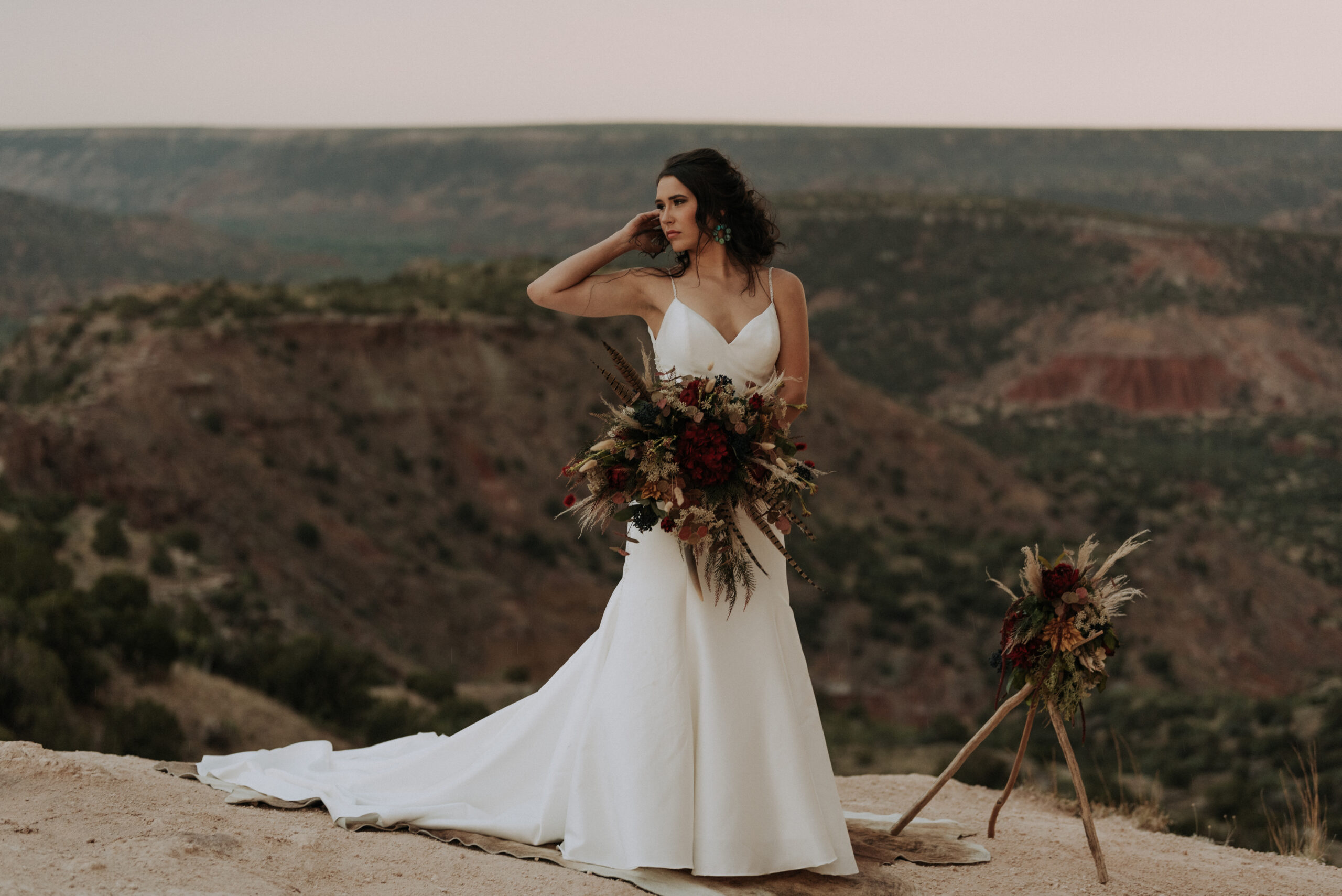 woman holding arm up while posing for bridal photos in the desert in Texas, destination wedding photographer and bridal portrait photographer